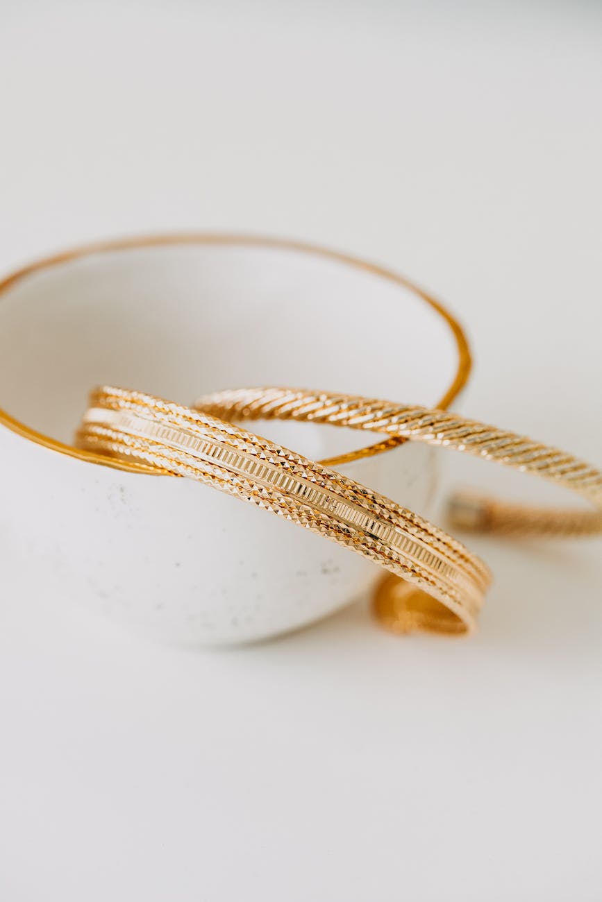 elegant golden bracelets with cup placed on table
